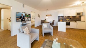 A modern apartment with a living room, dining area, and kitchen. - Dünenresort Binz - Apartment 4.1.6 (Binz)