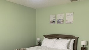 Un dormitorio con una cama, dos mesitas de noche, un ventilador de techo y una obra de arte en la pared.