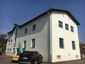 Un edificio de dos pisos con techo plano y varias ventanas.