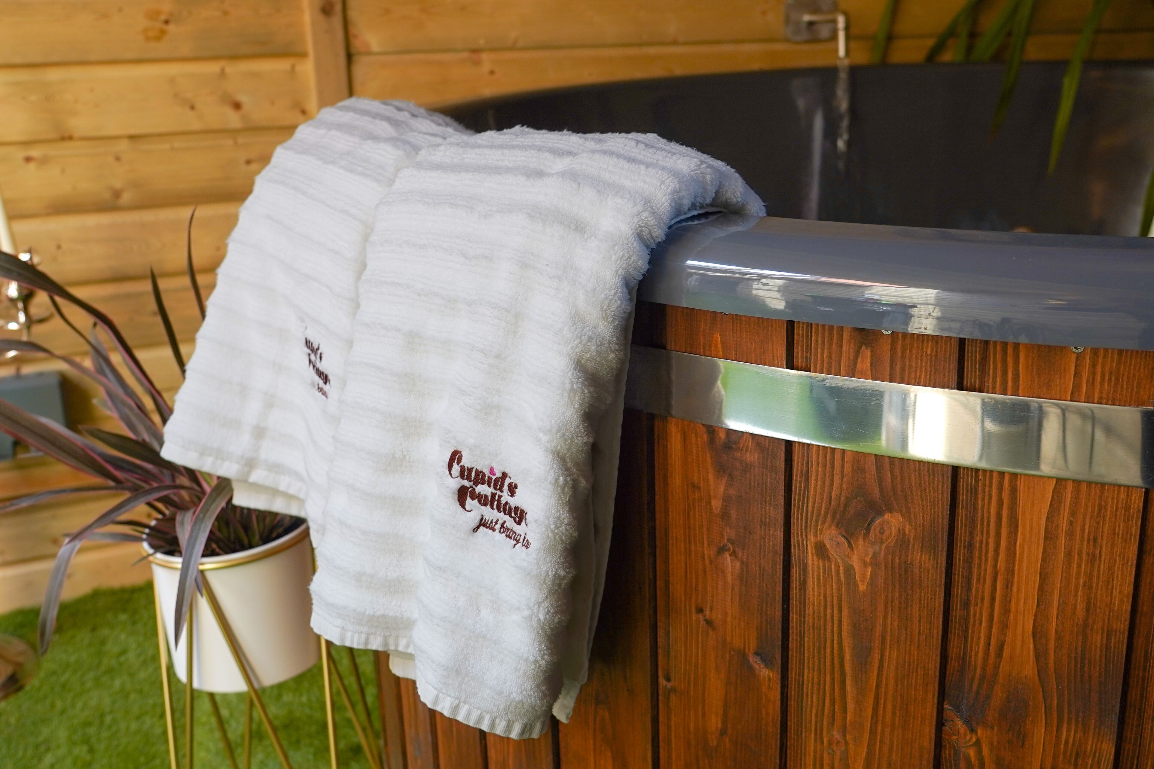 A wooden spa tub with a towel draped over it.