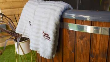A wooden spa tub with a towel draped over it.