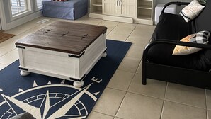 A living room with a large flat-screen TV, a blue sofa, a black sofa, a coffee table, and a decorative rug. - Peaceful lake house with private boat ramp and 2 docks (Jacksons' Gap)