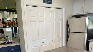 A kitchen with a dark wooden table, white double doors, and a refrigerator. - Peaceful lake house with private boat ramp and 2 docks (Jacksons' Gap)