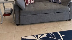 A living room with a gray sofa, two decorative pillows, a ceiling fan, and a dining area with a table and chairs. - Peaceful lake house with private boat ramp and 2 docks (Jacksons' Gap)