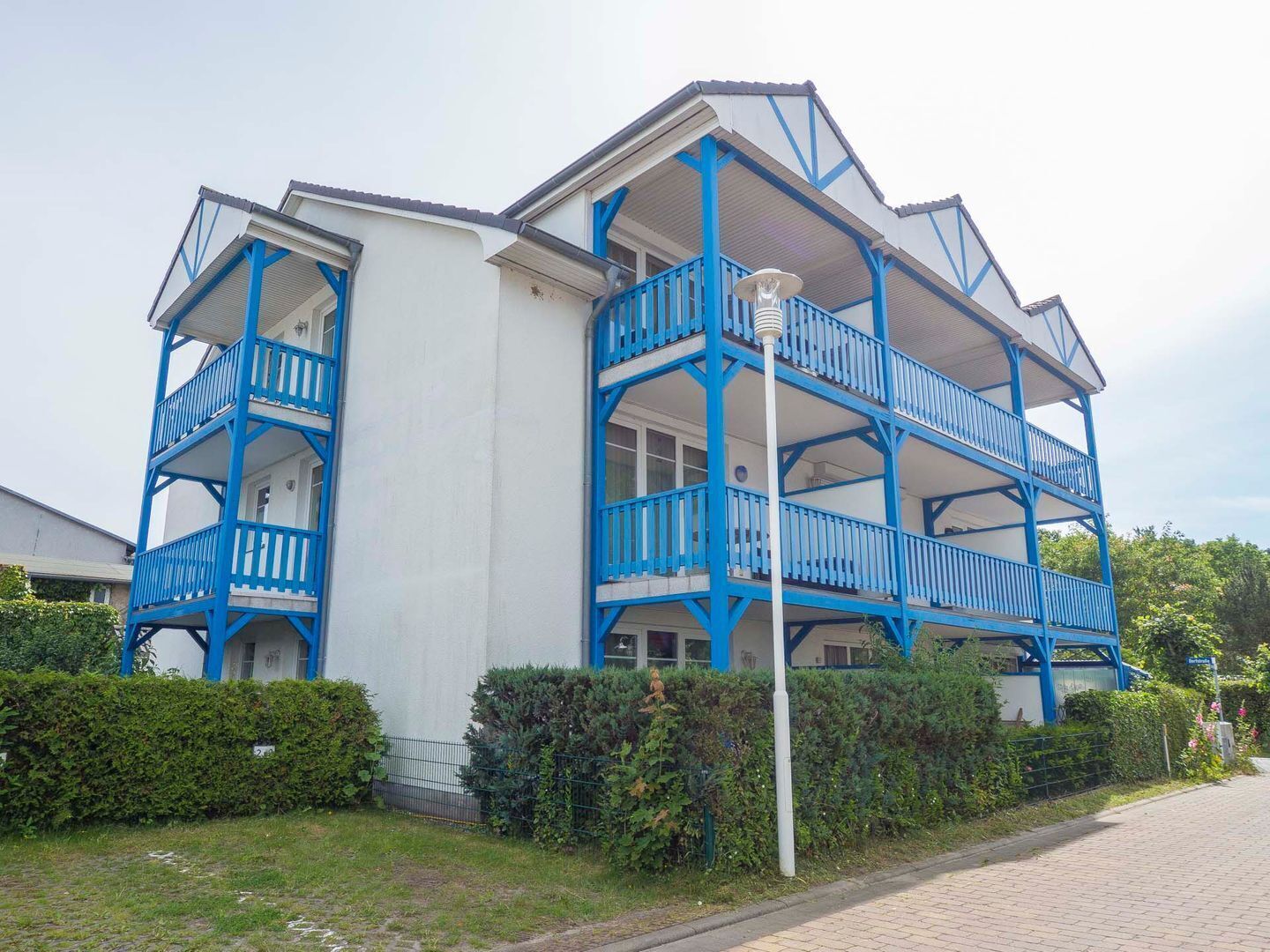 A multi-story building with blue balconies and white walls.