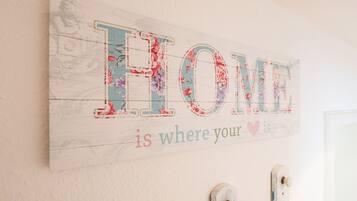 Un letrero decorativo con la palabra 'HOME' y la frase 'is where your heart is' en una pared.