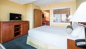 A hotel room with a bed, a desk, a television, a wardrobe, and a window with blinds. - Ocean Sands Resort Oceanfront condo with Oceanfront Balcony! (Virginia Beach)