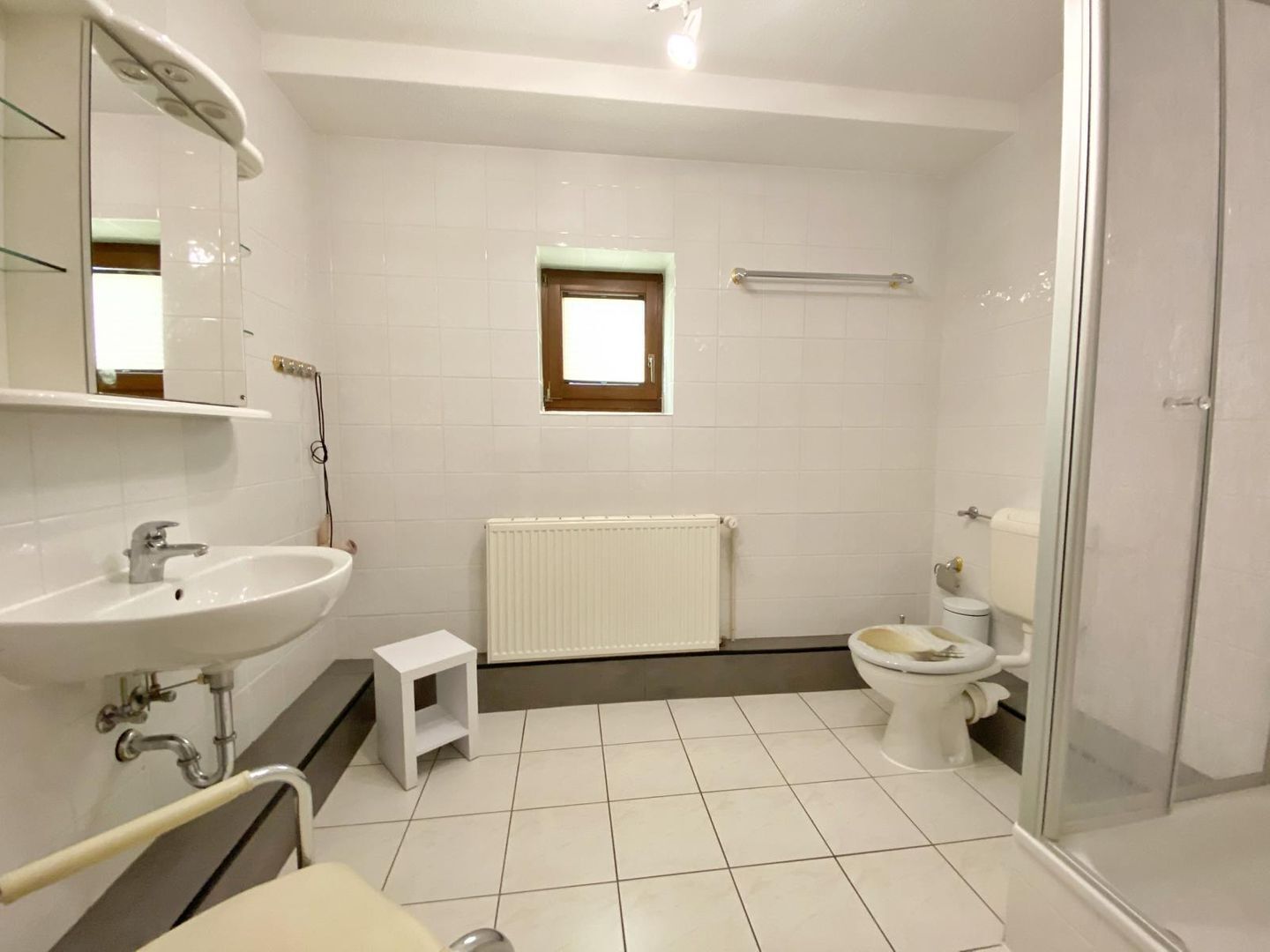 Ein modernes Badezimmer mit Waschbecken, Spiegel, Toilette und Dusche.