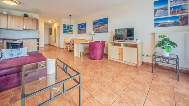 A spacious living area with a kitchen, dining table, and seating.