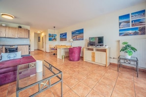 A spacious living area with a kitchen, dining table, and seating.