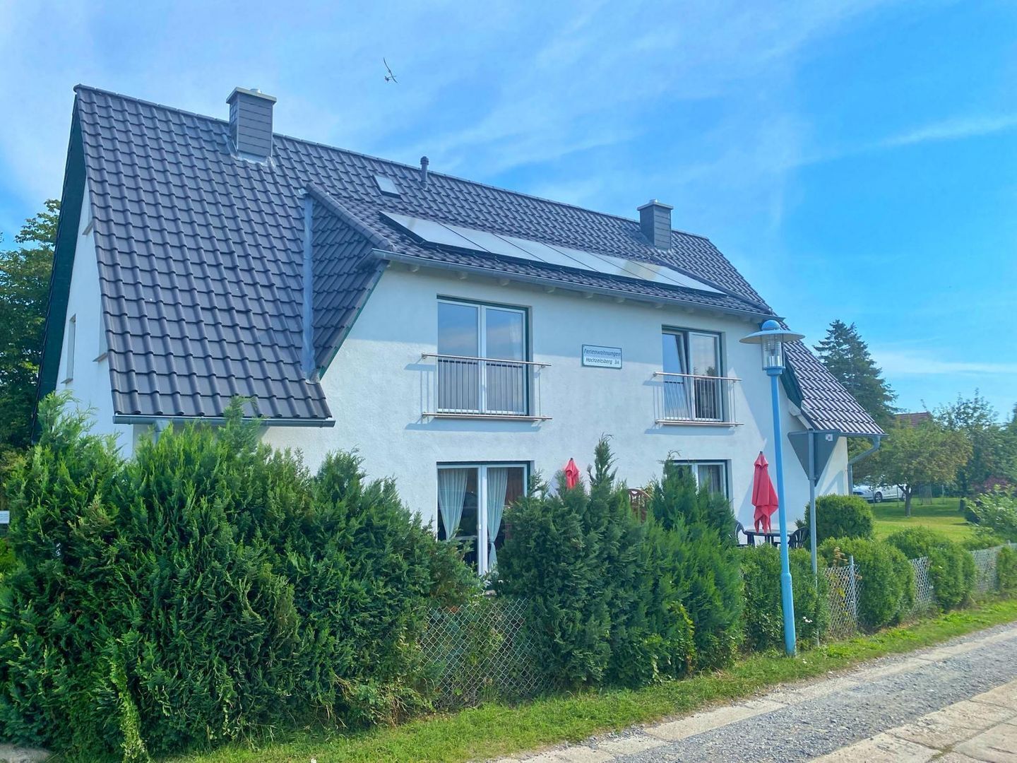 Une maison à deux étages, avec un toit recouvert de tuiles grises, un balcon au deuxième étage et une pancarte indiquant qu’il s’agit d’une résidence privée.
