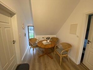 En matplats med ett runt träbord och fyra stolar av rotting.