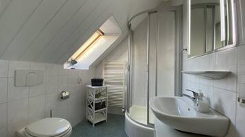 Ein kleines Badezimmer mit Toilette, Waschbecken und Dusche.