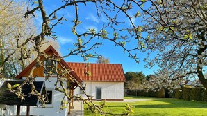 A house with a red-tiled roof, a white exterior, and a small porch.
