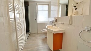 A modern bathroom with a shower, toilet, and sink. - Apartment 307 - Rondell an der Jasmundtherme - Neddesitz an der Jasmundperle / (Sagard)