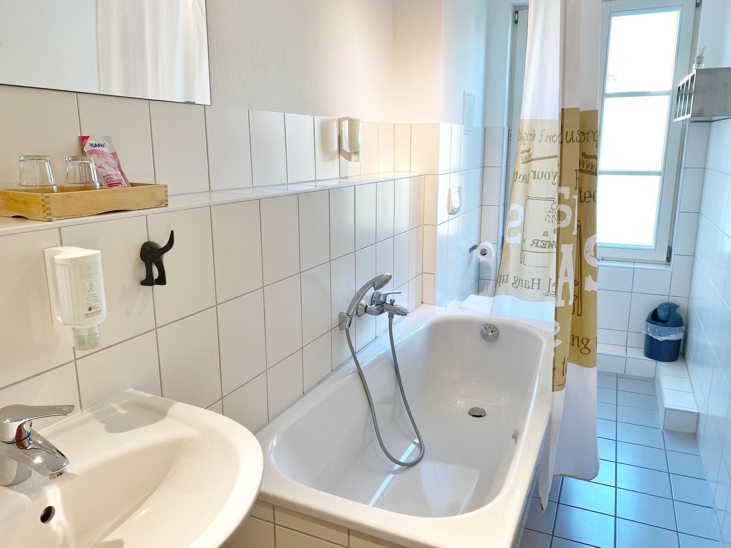 A modern bathroom with a bathtub, a sink, and a shower.