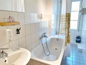 A modern bathroom with a bathtub, a sink, and a shower. - Seaside Appartements, "Grey" - Sassnitz - Seaside Appartements (Sassnitz)