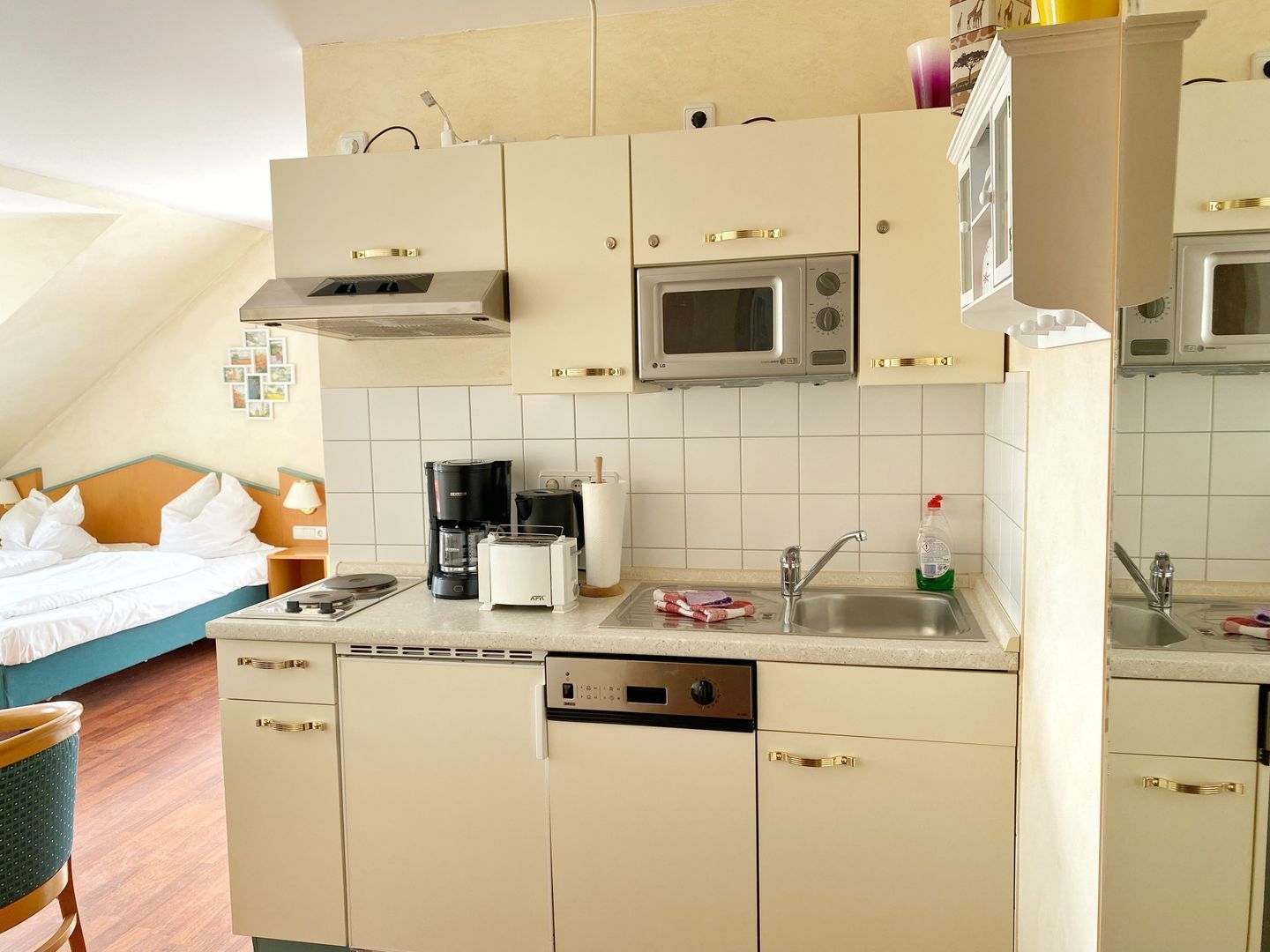 Une petite cuisine équipée d’un four à micro-ondes, d’une machine à café et d’un lave-vaisselle.