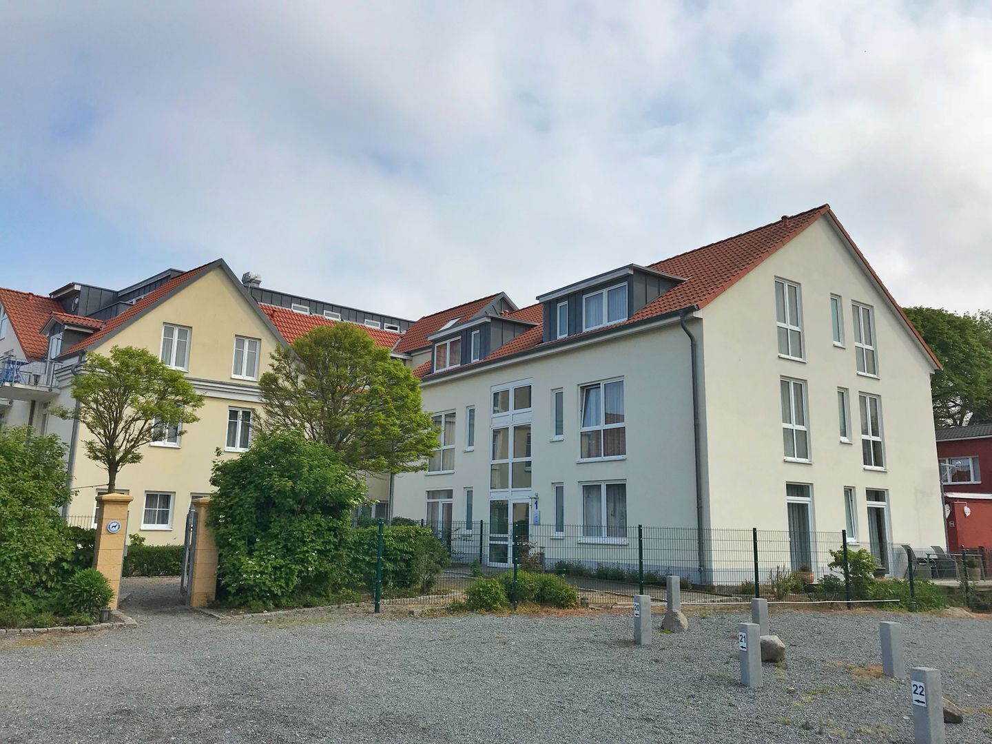 Eine Reihe moderner Wohngebäude mit roten Ziegeldächern und zahlreichen Fenstern.