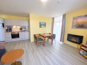 A compact living space with a kitchen, dining area, and a fireplace.