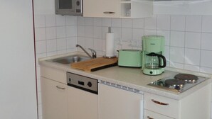Een keuken met een ingebouwde magnetron, een broodrooster, een koffiezetapparaat en een vaatwasser.