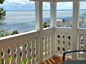 A covered balcony with a view of the sea, white railings, and a wooden floor. - Villa Jenny - Apartment 3 - Villa Jenny Sassnitz (Sassnitz)