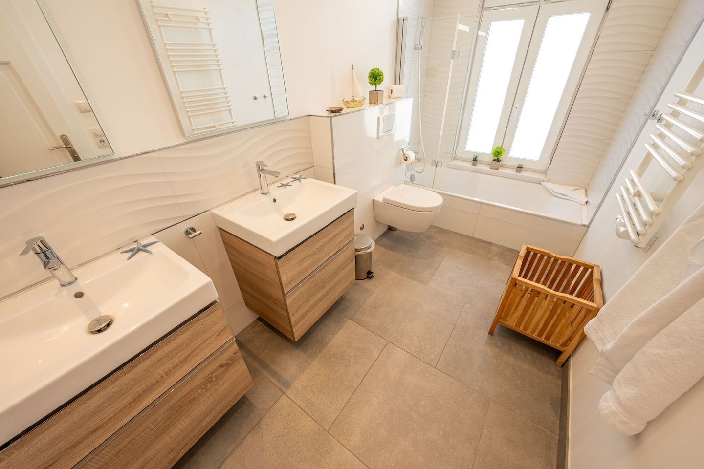 Ein modernes Badezimmer mit großem Spiegel, Waschbecken, Toilette und Dusche.