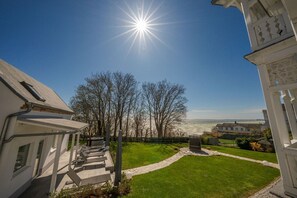 A residential property with a clear view of the sea, a well-maintained lawn, and a traditional architectural style. - Villa Jenny - Apartment 1 - Villa Jenny Sassnitz (Sassnitz)