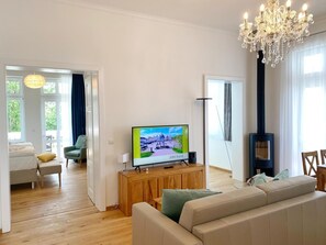 Een moderne woonkamer met een televisie, een houten kast en een groot raam.