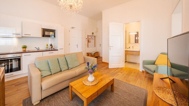 Un appartement moderne comprenant une cuisine, un salon et une salle de bain.