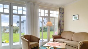 A room with a sofa, armchair, and a table with a lamp. - Vacation apartment 10 in the Villa Anna in Sassnitz - Sassnitz - Villa Anna (Sassnitz)