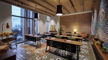 Un comedor moderno con ventanas amplias, pared de ladrillo y diversas opciones de asientos.