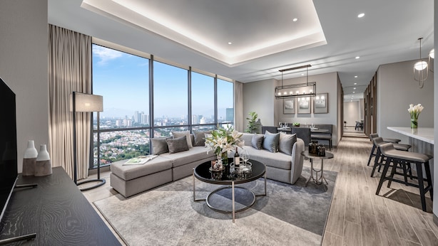 A modern living room with a large window, a sofa, a coffee table, and a dining area with a bar. - 25hours Hotel Jakarta The Oddbird (Jakarta)