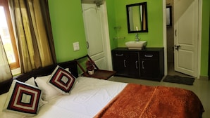 A bedroom with a bed, a nightstand, a dresser, a mirror, and a door. - Remarkable 1-Bed House in Bhimtal (Bhimtal)
