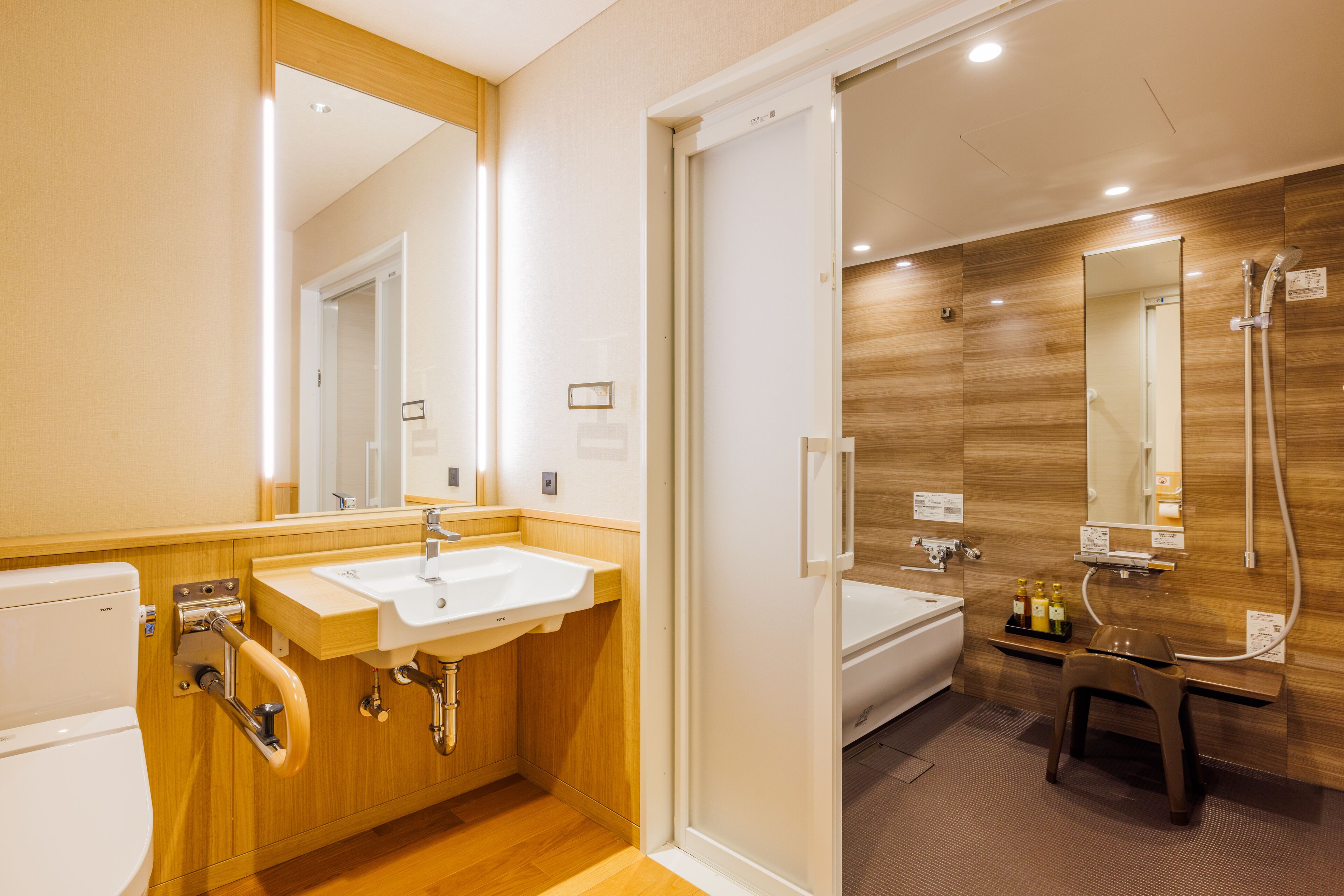 Une salle de bain moderne avec un lambris en bois, un lavabo, des toilettes et un espace douche.