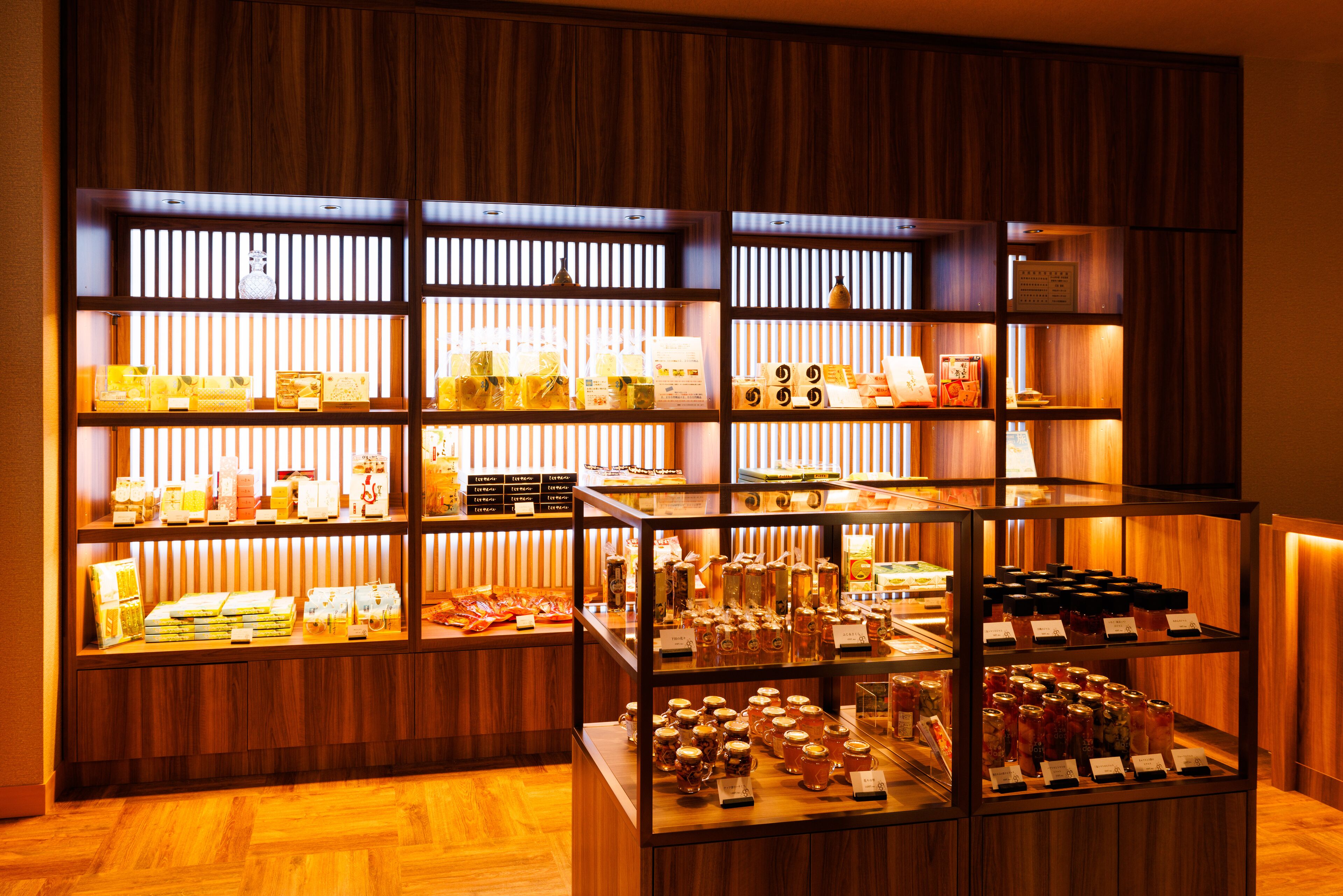 Una exhibición bien iluminada de diversos alimentos y bebidas en un ambiente con decoración de madera.