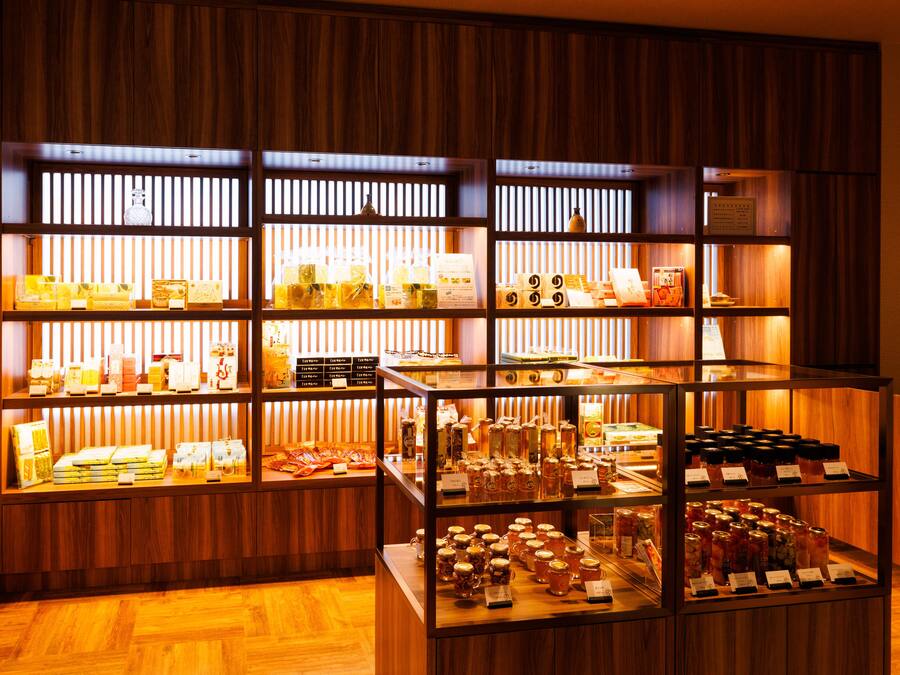 Una exhibición bien iluminada de diversos alimentos y bebidas en un ambiente con decoración de madera.