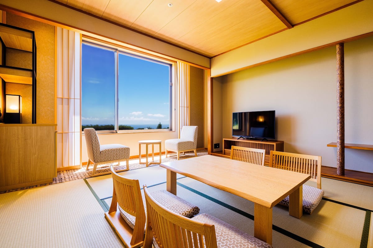 Une pièce de style japonais traditionnel, avec un sol recouvert de tatamis, une table en bois et des chaises.