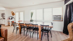 A modern kitchen with white cabinets, a wooden dining table, and black chairs. - Lake view, Pool, 2 miles to Bridge, 12 ppl (Lake Havasu City)