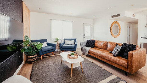 A modern living room with a sofa, armchairs, a coffee table, and a TV. - Lake view, Pool, 2 miles to Bridge, 12 ppl (Lake Havasu City)