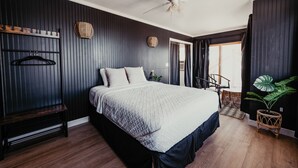 A bedroom with a bed, a bench, a ceiling fan, and a large window with curtains. - Lake view, Pool, 2 miles to Bridge, 12 ppl (Lake Havasu City)