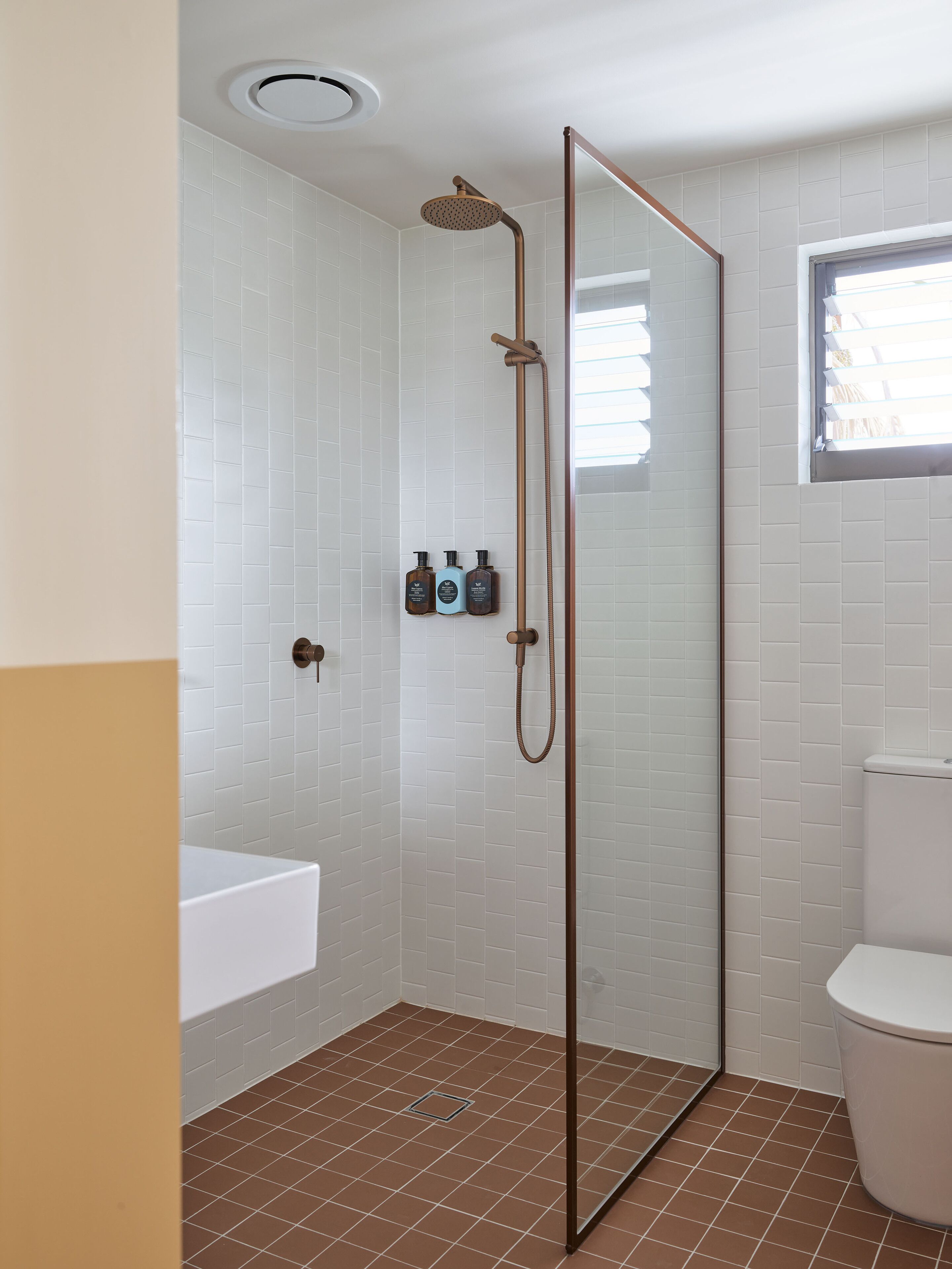 A bathroom with a shower, a toilet, and a sink.