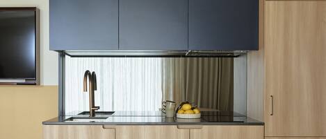 Una cocina moderna con armarios de madera, estufa integrada y un comedor con mesa y sillas de madera.