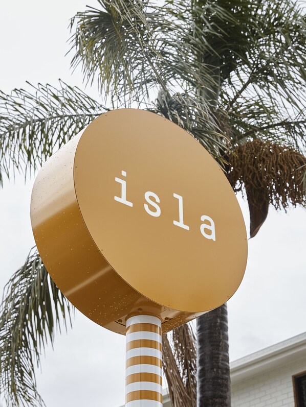 A circular sign with the word "isla" on it, mounted on a pole with a striped pattern.