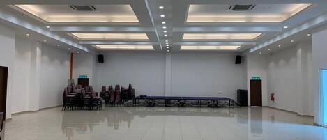 A spacious conference room with a long table and chairs, recessed ceiling lighting, and a polished floor.