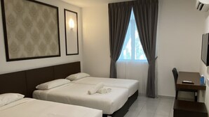 Quarto de hotel com duas camas, uma escrivaninha, uma cadeira, uma televisão e uma janela com cortinas.