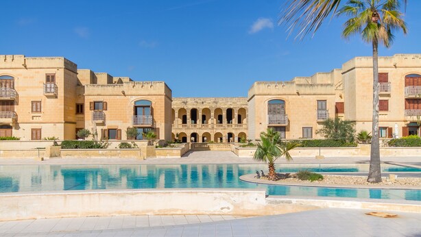 A large building with multiple balconies and a central courtyard with a swimming pool. - Harbour Views Gozitan Villa + Shared Pool, Mġarr Gozo, Malta (Mġarr Gozo)