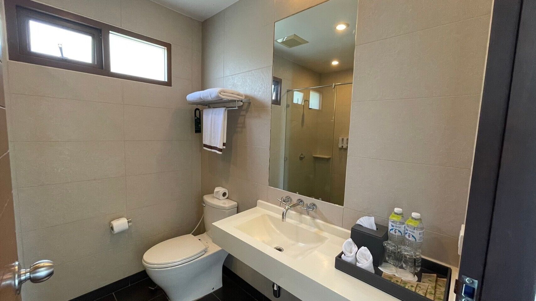 A compact bathroom with a toilet, sink, and mirror.