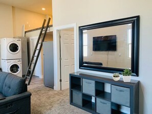 Relax in this compact living space with a large flat-screen TV, entertainment unit, and comfortable sofa.