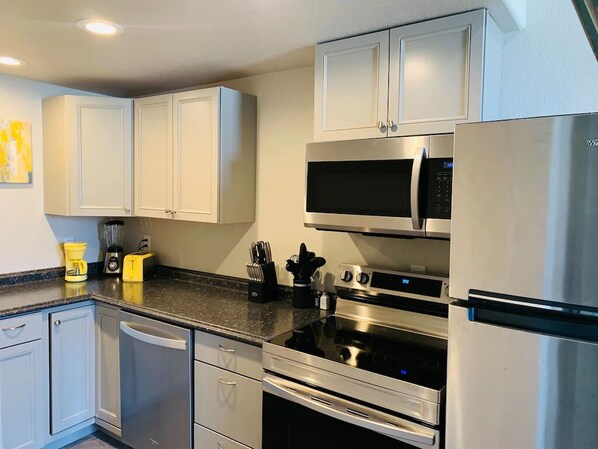 Enjoy cooking in this fully equipped kitchen with a microwave, oven, refrigerator, coffee maker, and blender.